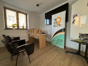 Biurko szkoleniowca, krzesła dla kursantów, roll-up TuSięUcz.pl - zdjęcie sali szkoleniowej.