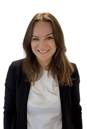 uśmiechnięta właścicielka firmy, ubrana w biały t-shirt i czarną marynarkę.